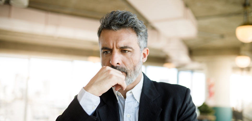 A concerned businessman working at his computer in an office