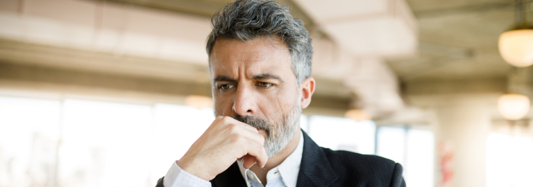 A concerned businessman working at his computer in an office.