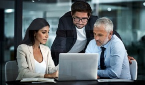 Three businesspeople looking at the screen of a laptop computer