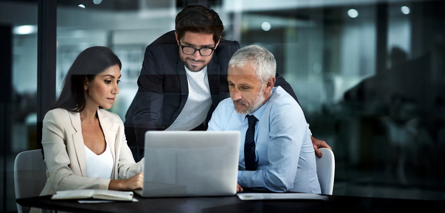Three businesspeople looking at the screen of a laptop computer